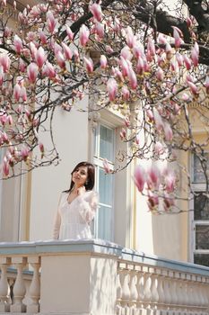 Beautiful brunette girl in Garden with blooming magnolia trees