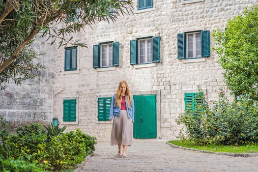 Woman tourist enjoying Colorful street in Old town of Kotor on a sunny day, Montenegro. Travel to Montenegro concept.