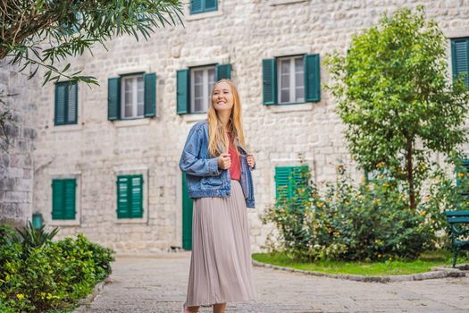 Woman tourist enjoying Colorful street in Old town of Kotor on a sunny day, Montenegro. Travel to Montenegro concept.