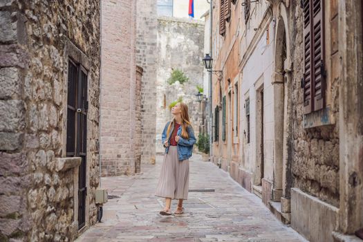 Woman tourist enjoying Colorful street in Old town of Kotor on a sunny day, Montenegro. Travel to Montenegro concept.