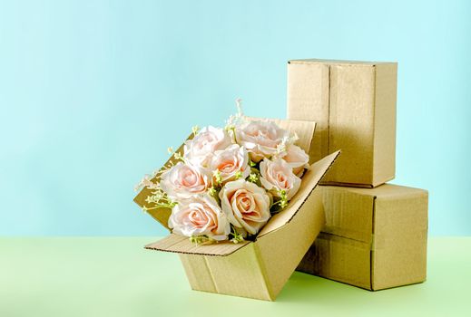 A blooming bouquet of pink roses in a cardboard box of a delivery service for congratulations on Valentine's Day or a wedding or other holiday.