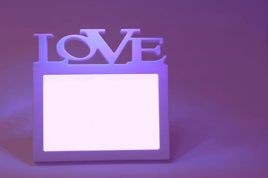 a rigid structure that surrounds or encloses something such as a door or window. White frame with the inscription love on a purple-pink background.