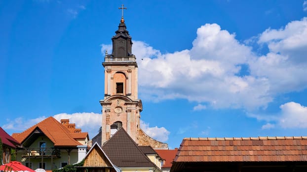 the principal church of a diocese, with which the bishop is officially associated.High bell tower of the old catholic cathedral in the medieval city.