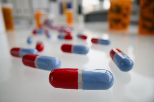 Close-up of red and blue pills on glass surface. Medication in capsules. Pharmacy, antibiotics or vitamins. Medicine, healthcare and treatment concept