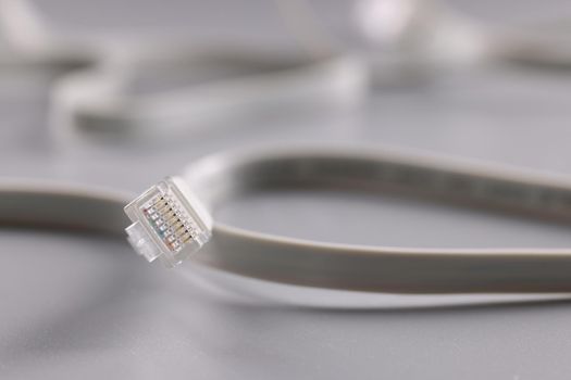 Close-up of internet connectors on grey background, cable with plastic clip. Internet and telecommunications, modern technology and service concept