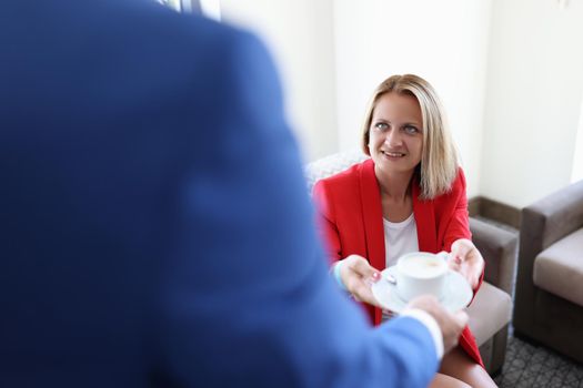 Close-up of business meeting in office and coffee break. Businesspeople drinking coffee together and discussing terms of contracts