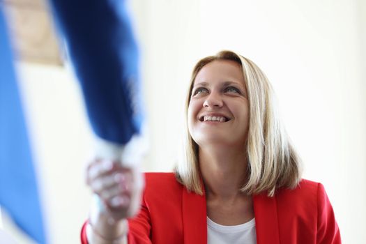 Close-up of business partners handshaking after signing profitable contract. Colleagues shaking hands after bargaining or successful agreement. Good deal concept