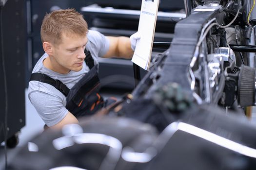 Portrait of concentrated male mechanic work with tool, fix damaged motorbike at workshop. Mechanic repair old detail. Pit stop, service help, maintenance concept