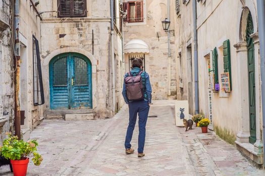 Man tourist enjoying Colorful street in Old town of Kotor on a sunny day, Montenegro. Travel to Montenegro concept.