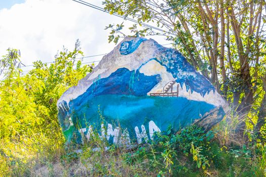 Quintana Roo Mexico 04. February 2022 Colorful stone rock boulder with lettering font symbol statue at the amazing blue turquoise water and limestone cave sinkhole cenote Tajma ha Tajmaha Mexico.