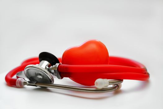 Stethoscope and red heart on white background, heart health, health insurance concept.