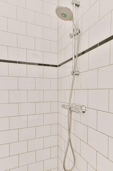 Bathroom interior with a shower, white tiles on the walls and black on the floor in a modern house