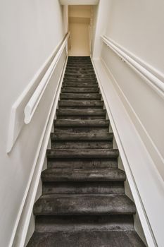 A spacious corridor with a straight carpet staircase leading up to a cozy house