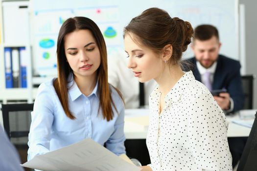 Portrait of businesswomen working together at company office, teamwork and teambuilding. Colleagues discussing details of project development