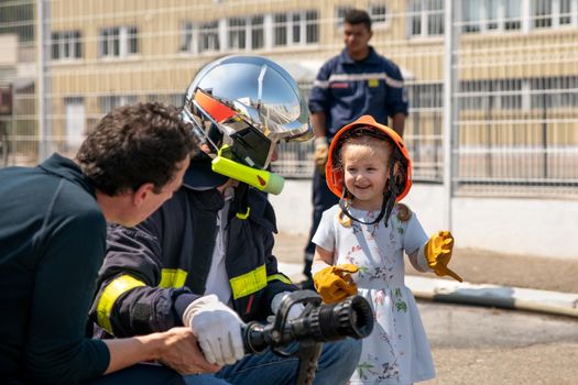 Fire uniformed father teaches his daughter Firefighter