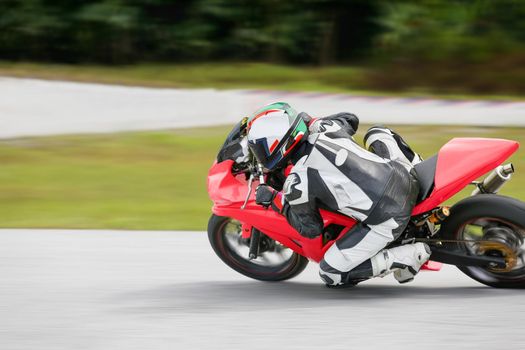 Motorcycle practice leaning into a fast corner on track