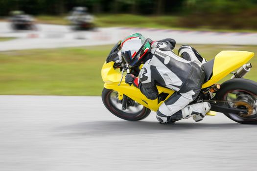 Motorcycle practice leaning into a fast corner on track