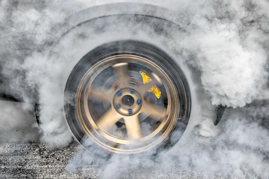 Drag racing car burns rubber off its tires in preparation for the race