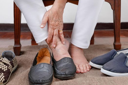 Elderly woman putting on shoes wrong feet