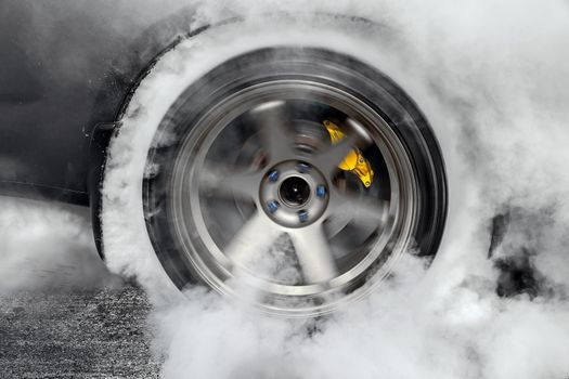 Drag racing car burns rubber off its tires in preparation for the race