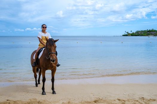 horse riding on the beach, woman on a horse on the beach during a luxury vacation in Mauritius.