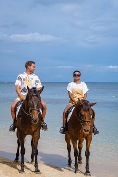 horse riding on the beach, man and woman on a horse on the beach during a luxury vacation in Mauritius.