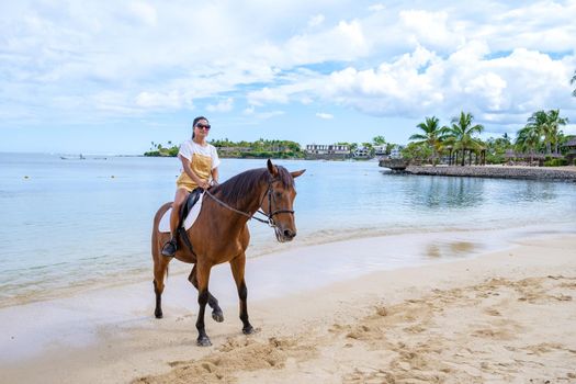 horse riding on the beach, woman on a horse on the beach during a luxury vacation in Mauritius.