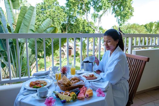 women mid age having breakfast on the balcony of an apartment luxury hotel condo in Mauritius. during a luxury vacation holiday