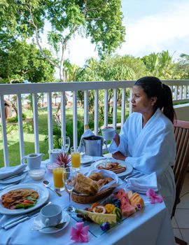 women mid age having breakfast on the balcony of an apartment luxury hotel condo in Mauritius. during a luxury vacation holiday