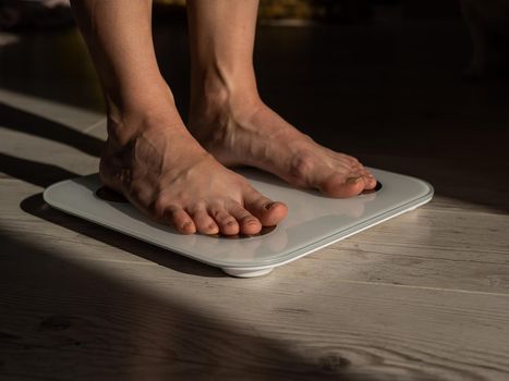 Close-up of female legs on electronic scales