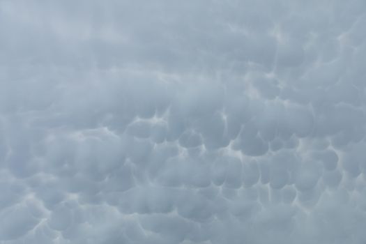A wide frame as storm clouds gather in the sky, clustered in many irregular bubbles squeezed one next to another.