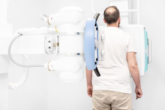 Man in x-ray room having medical scan examination in a modern hospital. High quality photo