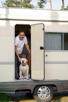 the concept of traveling in a motorhome. man traveling with dog