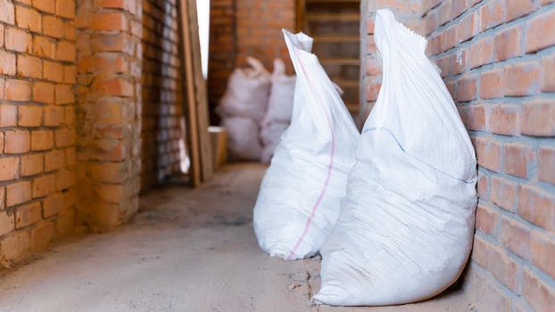 Bags with construction debris lie at a construction site close-up