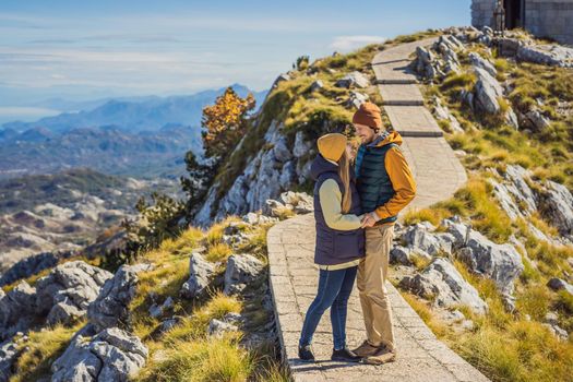 Couple man and woman tourists in mountain landscape at national park Lovcen, Montenegro. Travel to Montenegro concept.