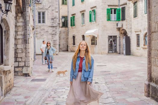 Woman tourist enjoying Colorful street in Old town of Kotor on a sunny day, Montenegro. Travel to Montenegro concept.