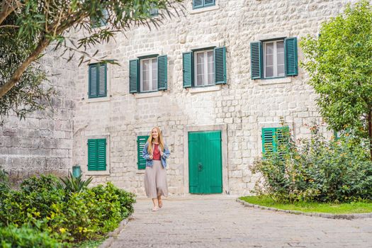 Woman tourist enjoying Colorful street in Old town of Kotor on a sunny day, Montenegro. Travel to Montenegro concept.