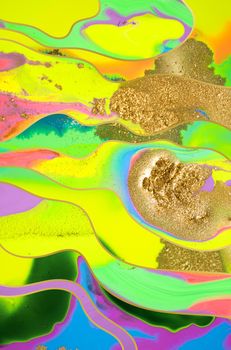 Gold dust and waves on fluorescent inks background