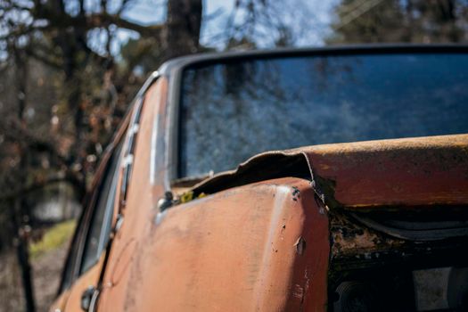 Old red abandoned car in the mountain view from the back