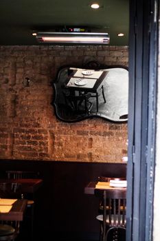 Restaurant table reflected in a mirror on a bricks wall