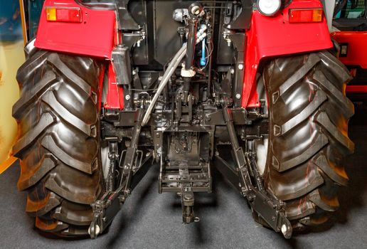 The hydraulic system for installing attachments and the power take-off shaft on the tractor - wheeled agricultural machinery, close-up rear view.