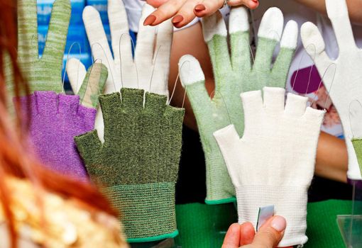 Women's bright gloves, fingerless and full-fingered from fabric of various colors, women's hands make a choice.