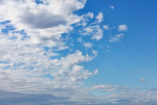 White fluffy clouds spread across the sky, revealing pure blue and splitting the picture in half.