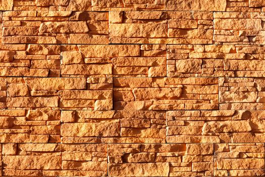 Sunlight hard illuminates an orange stone background from old tiles.