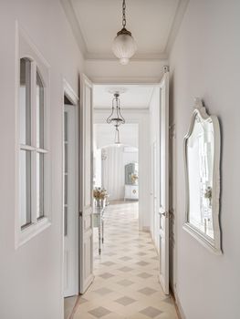 Hallway with vintage chandeliers overlooking a long corridor with many doors to the rooms