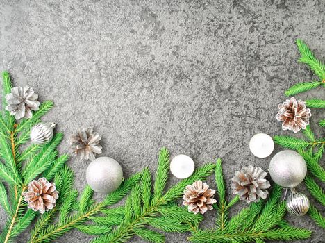 Christmas and Happy New Year gray stone background. Top view, copy space, military stile. Fir branches, a silver concrete