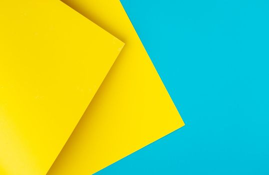 Yellow and blue colored background of overlapped cardboard layered geometric shaped sheets. Abstract design concept. Surface elements. Shredded texture, craft backdrop