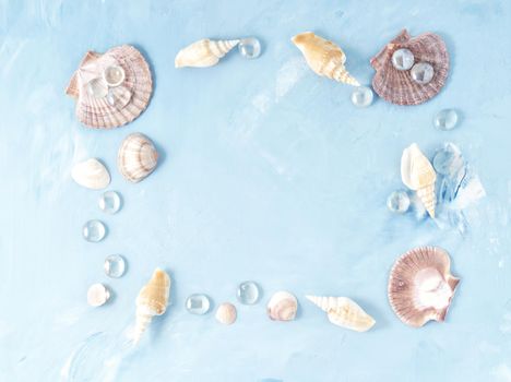 Mock up with frame of seashell on a blue stone background, scallop shell, copy space. Summer concept of holiday by sea