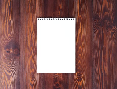 The open notepad with spiral on a dark brown wooden table, top view
