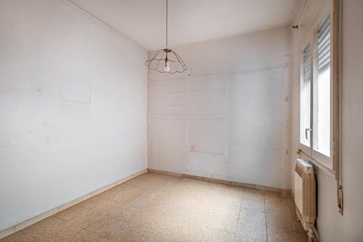 Empty, old and dirty room with white walls and traces of shelves.